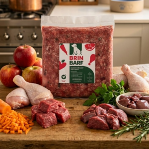 Vianda de alimento BARF de pollo para perros con ingredientes frescos: carne, vísceras, frutas y verduras sobre tabla de madera.